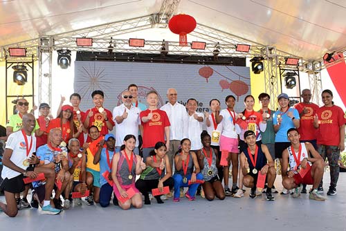 Al centro el embajador Chen Luning, Rafael Salazar, Miguel Feng y José Ramón Holguín, Wendy Reynoso y Elpidio Vargas junto a los corredores ganadores de los 5K.